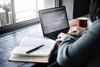 Frau am Laptop mit Terminplaner